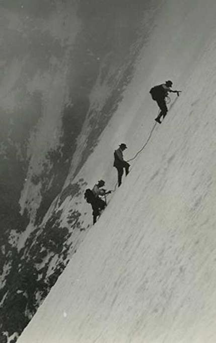 Three climbers up a large, steep, snowy mountain