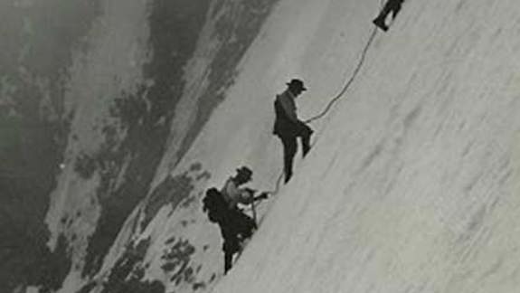 Three climbers up a large, steep, snowy mountain
