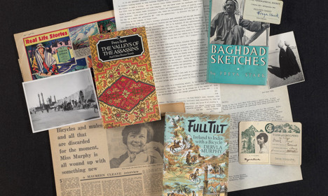 A collection of ephemera including typed documents, books, and newspaper cuttings.