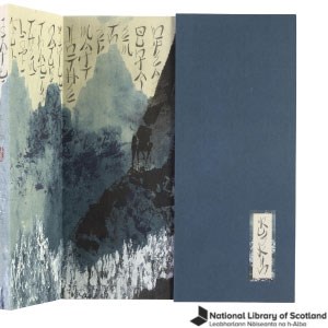 An image of a bookbinding with Japanese writing and painted mountains in shades of blue. There is a black National Library of Scotland logo in the bottom right.