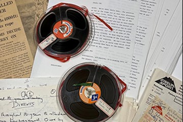 A selection of paper ephemera and two reels spread out flat.