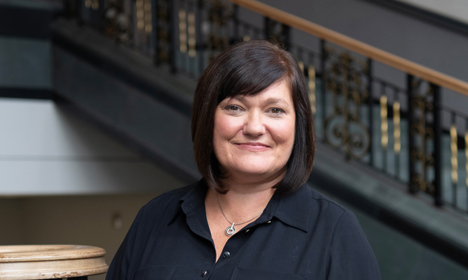 Portrait photo of Anne Boyle standing on the main staircase in the Library.