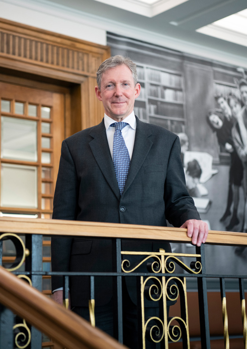 Christopher Smith standing at the top of stairs at the Library.