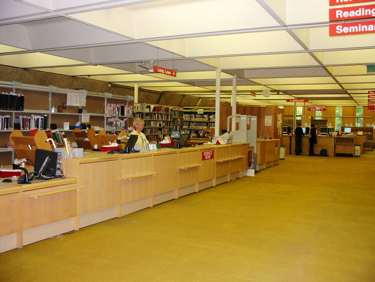 The inside of St Andrew's library with yellow carpet and the issues desk.