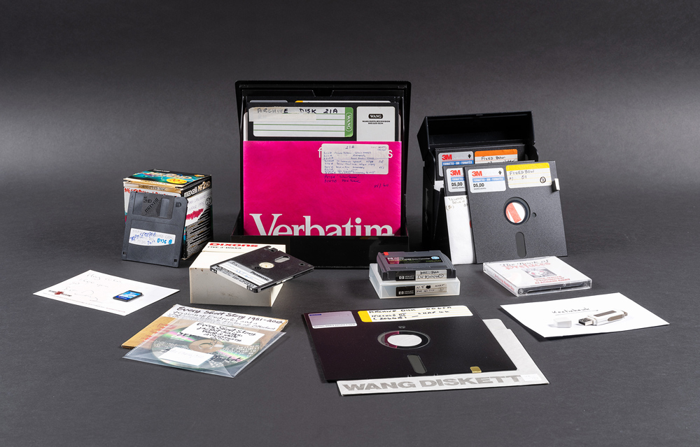 A collection of older technology including floppy disks, SD cards, and CD-ROMs.