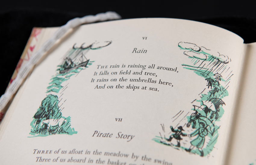 A poem called 'Rain' by Robert Louis Stevenson, surrounded by an illustration showing rain and people with umbrellas.