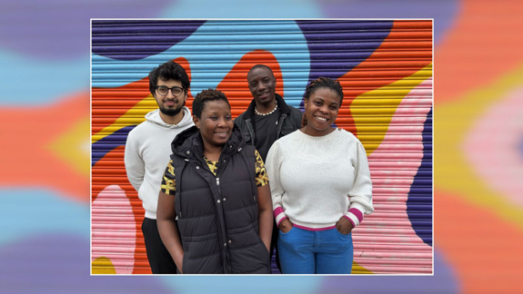 Four film-makers stand in front of a muti-coloured background.