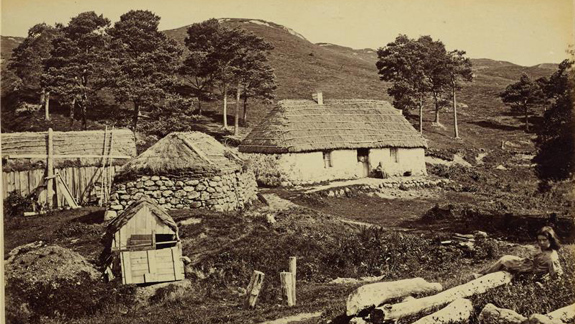 An old black and white photo of an old style house in the country in Scotland.
