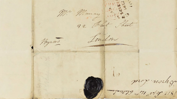 The outside of an old letter addressed to its recipient with a black wax seal at the bottom.