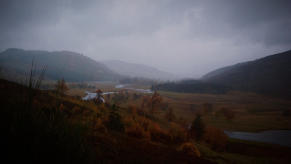 A moody photo of a Scottish Highland landscape on a dark drizzly day.