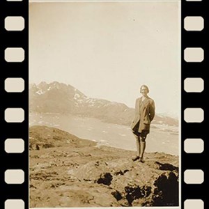 A sepia-toned photograph of Isobel Wylie Hutchison standing in the mountains. The photo has been repeated three times in a row and a graphic of a filmstrip is around each one.