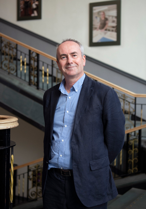 Anthony Gillespie standing on a staircase.