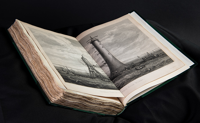 An open book showing drawings of lighthouses.