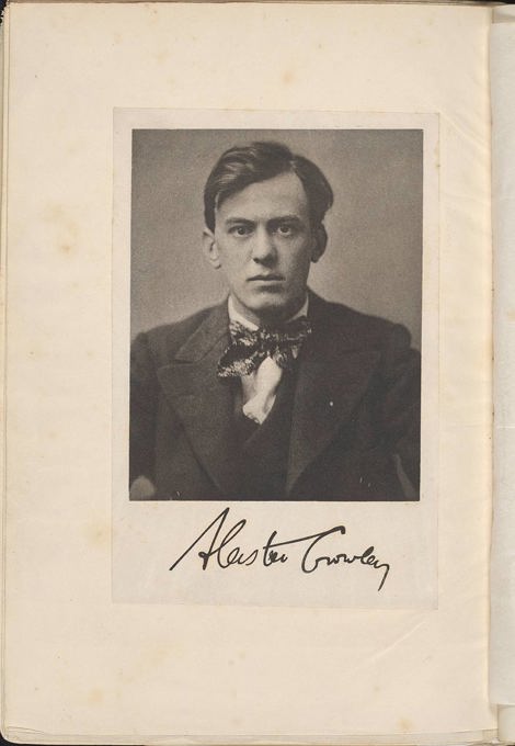 An old black and white photograph of a man with dark hair, a suit and bow tie looking directly at the camera, unsmiling.