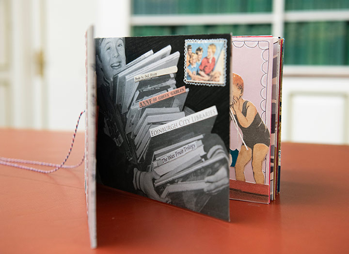 A book standing with pages open revealing a stack of library books