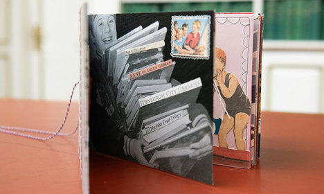 A book standing with pages open revealing a stack of library books