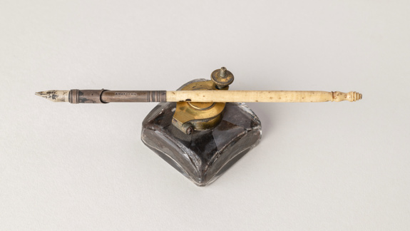 An old metal-nibbed pen and ink pot.