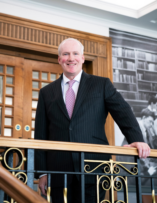 Donald Davidson standing on the stairs leading to the General Reading Room.
