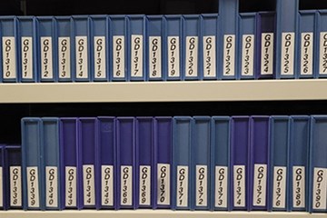 Two shelves full of tapes in blue cases.