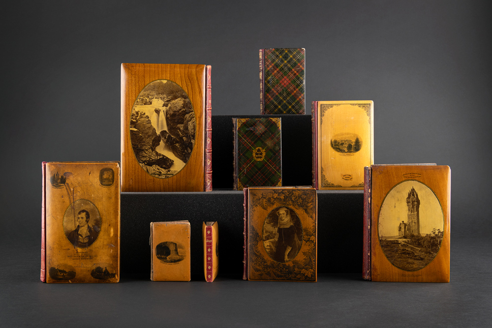 A series of books with Mauchline-ware bindings showing Scottish landscapes and people.
