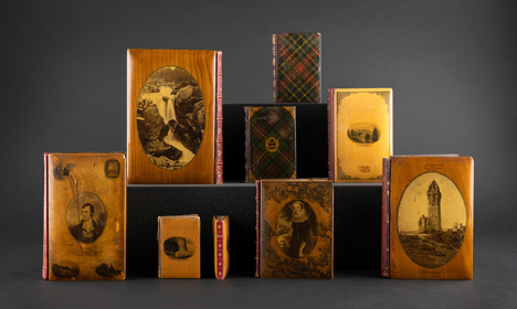 A series of books with Mauchline-ware bindings showing Scottish landscapes and people.
