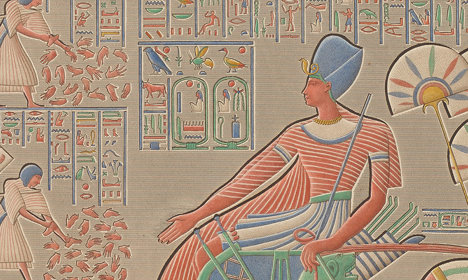 Closer view of the ruler in a chariot with hieroglyphic inscriptions around them.