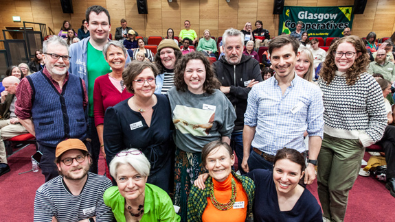 A group of people posing for a photo in a lecture theatre.