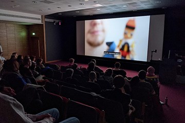 People sitting in a cinema watching a film.