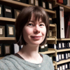 Head and shoulders of a lady in front of a bookcase.
