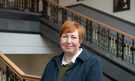 Alison Stevenson standing on a staircase.