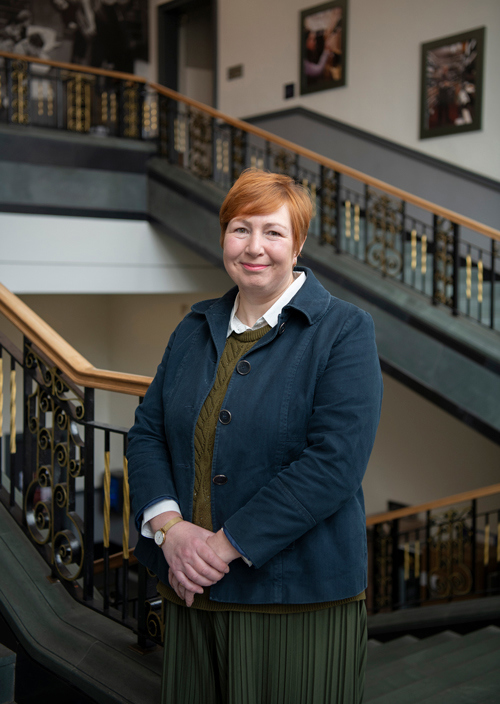 Alison Stevenson standing on a staircase.