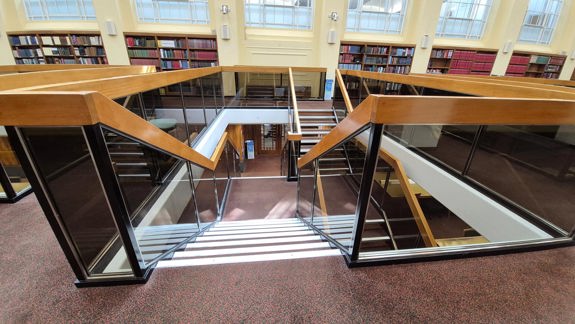 Stairs going down from the mezzanine level of the General reading room. There are rails on either side.