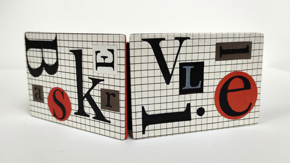 A contemporary bookbinding showing a cover covered in cut out letters.