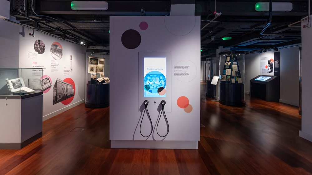 A long shot of the Treasures exhibition showing two listening devices telling about the Library's history.