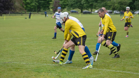 A shinty match being played in a field.