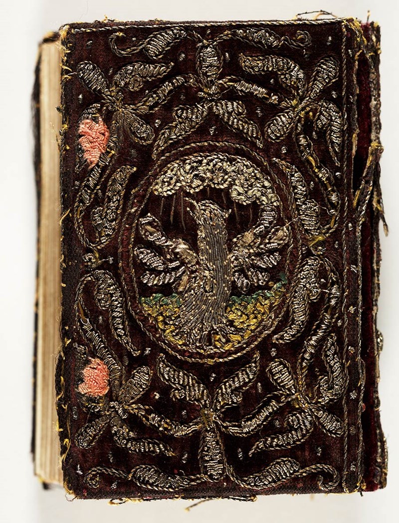 An embroidered phoenix done in metallic threat. It is surrounded by a pattern.