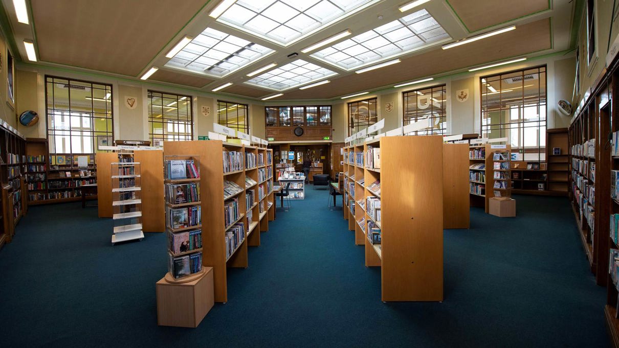 The inside of a public library with shelves full of books.